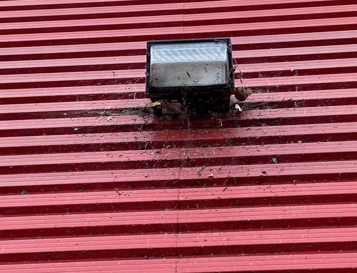 Lumière sur un mur rouge avec des détritus avant le nettoyage à pression